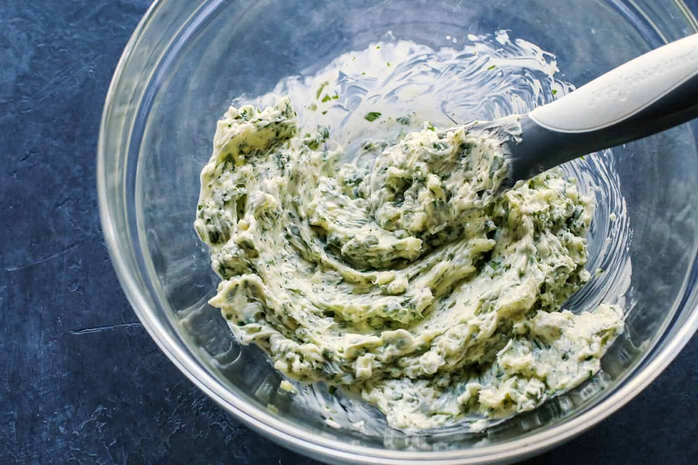 Cheesy garlic bread is the best, with buttery, toasted bread that's soft inside, crispy outside, and loaded with fresh herbs and melty cheese. Homemade garlic butter mixed in a bowl.