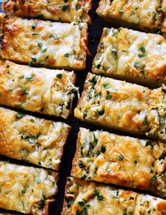 Overhead view of cheesy garlic bread cut into slices.