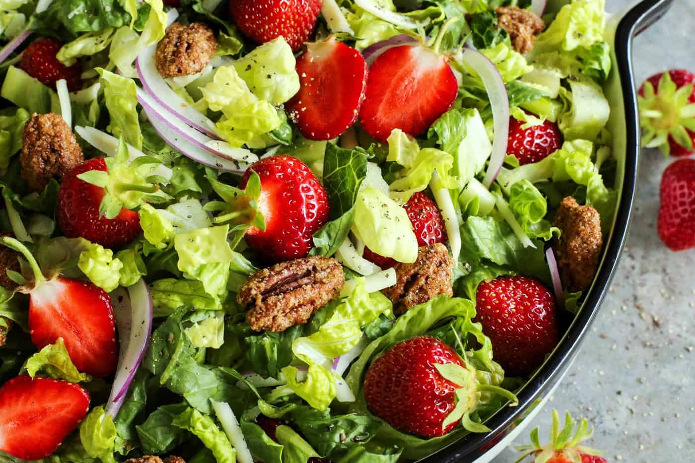 This strawberry salad with red wine vinaigrette has Monterey Jack cheese and ridiculously crunchy candied pecans. It's a crowd-pleaser! candied pecans on a strawberry salad