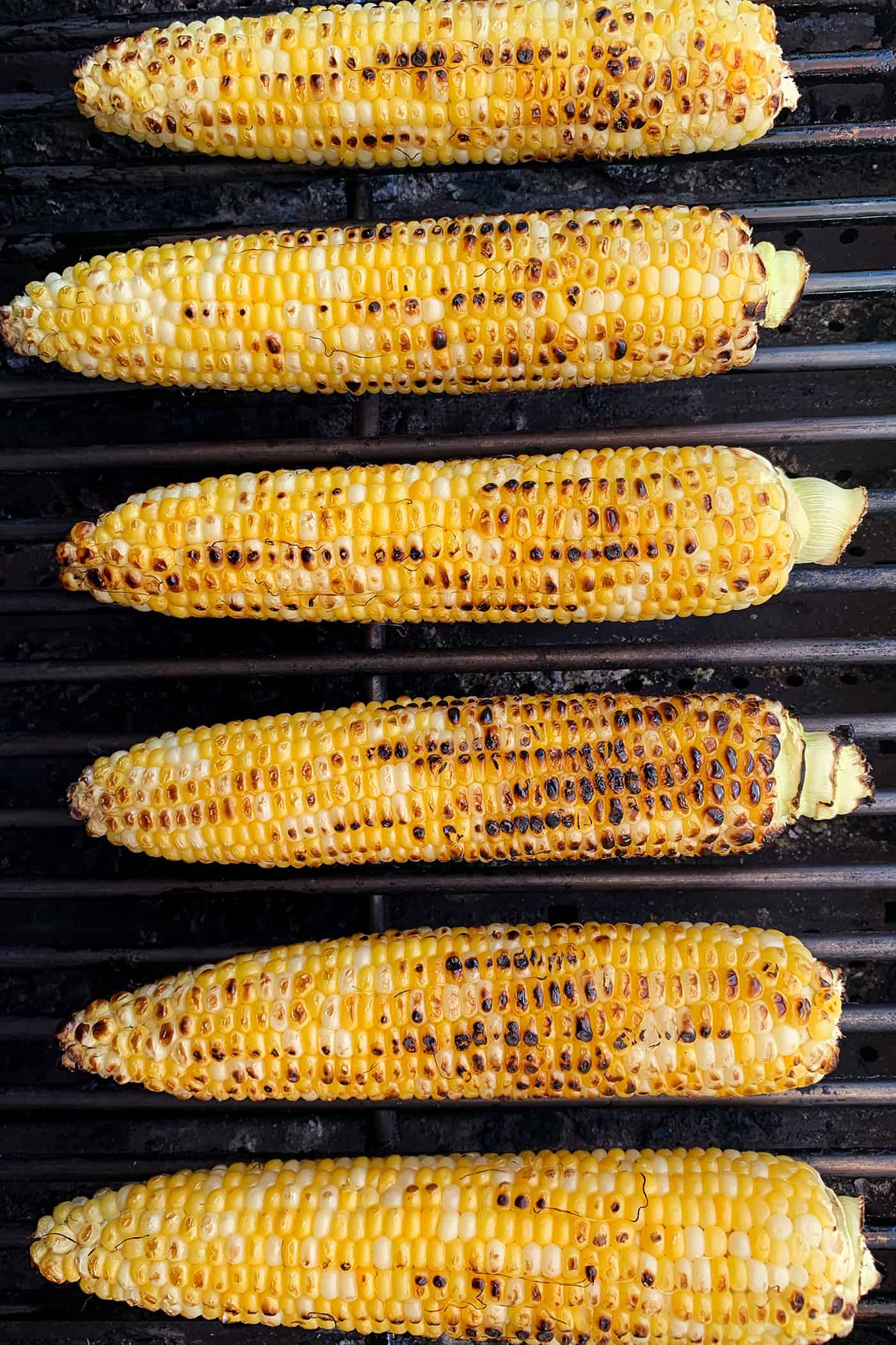 This Mexican Corn Salad, known as esquites, features grilled corn, a tangy, creamy dressing, and plenty of spice. ears of sweet corn on the grill
