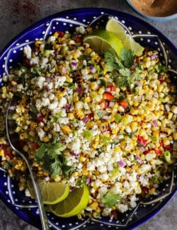 Mexican corn salad in a dark blue pottery bowl