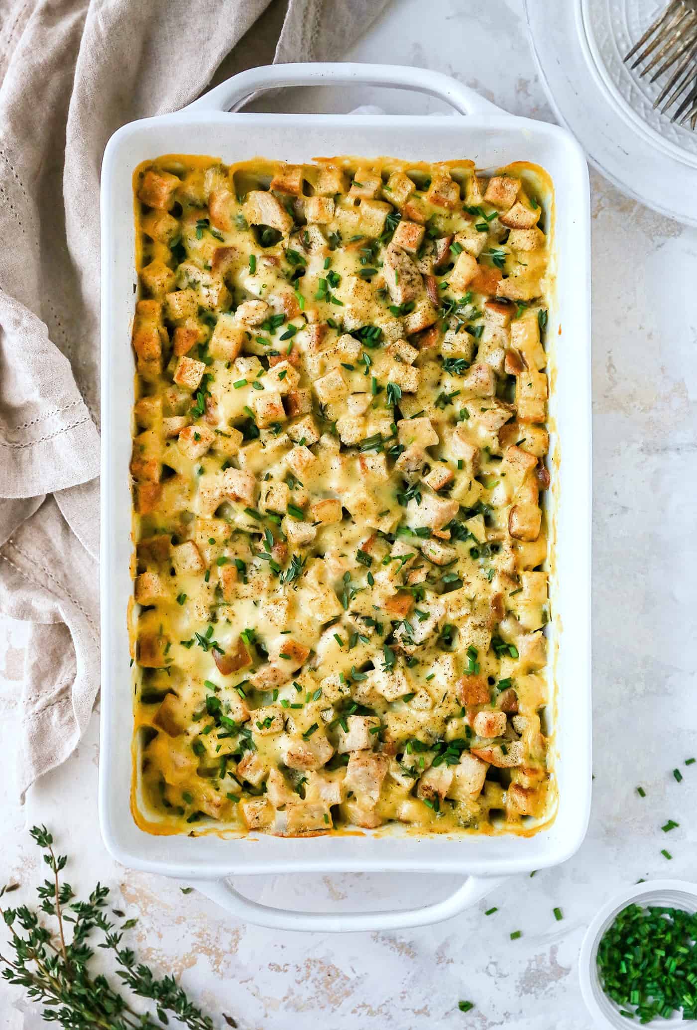This hearty leftover turkey casserole recipe with sage, thyme, cream of chicken, and crispy stuffing is an easy way to clean out the fridge. Leftover turkey casserole straight out of the oven, garnished with fresh thyme and crunchy chives.