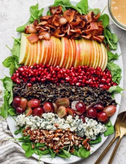 Assembled wild rice salad on the serving platter with maple-Dijon dressing on the side.