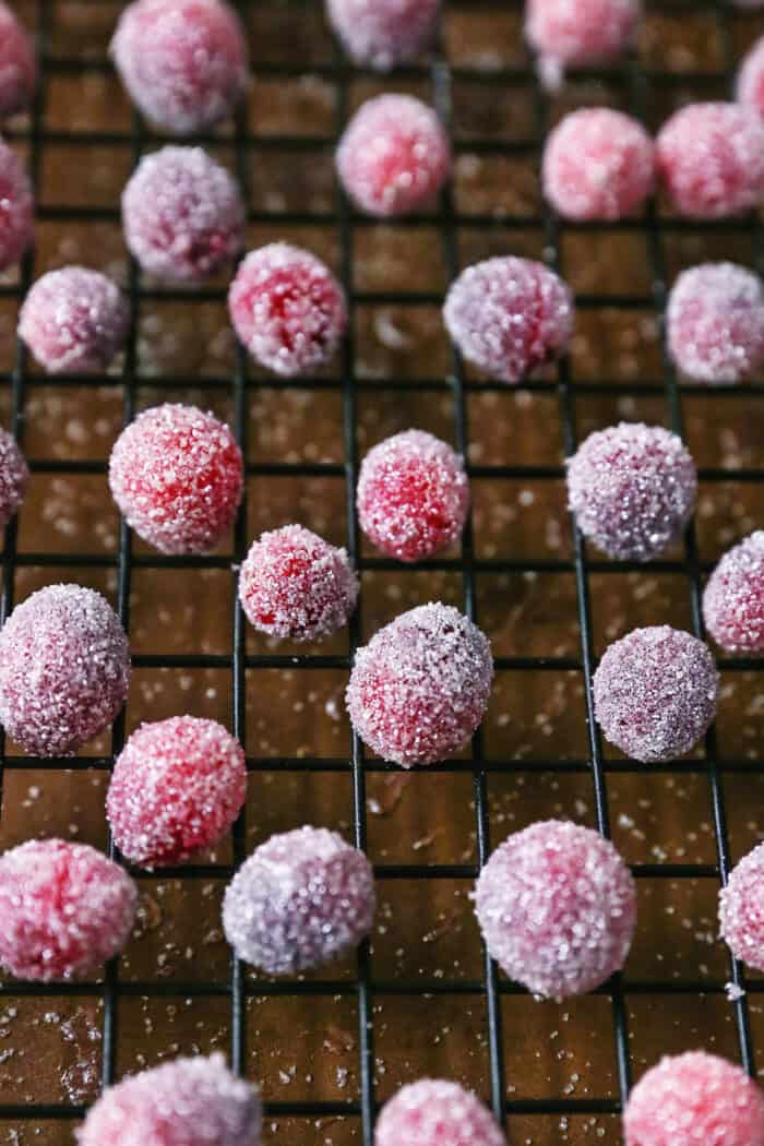 Sugared cranberries are the perfect sparkling finish for all your holiday desserts! All it takes is fresh cranberries, sugar, and water. Sugared cranberries drying on a cooling rack.