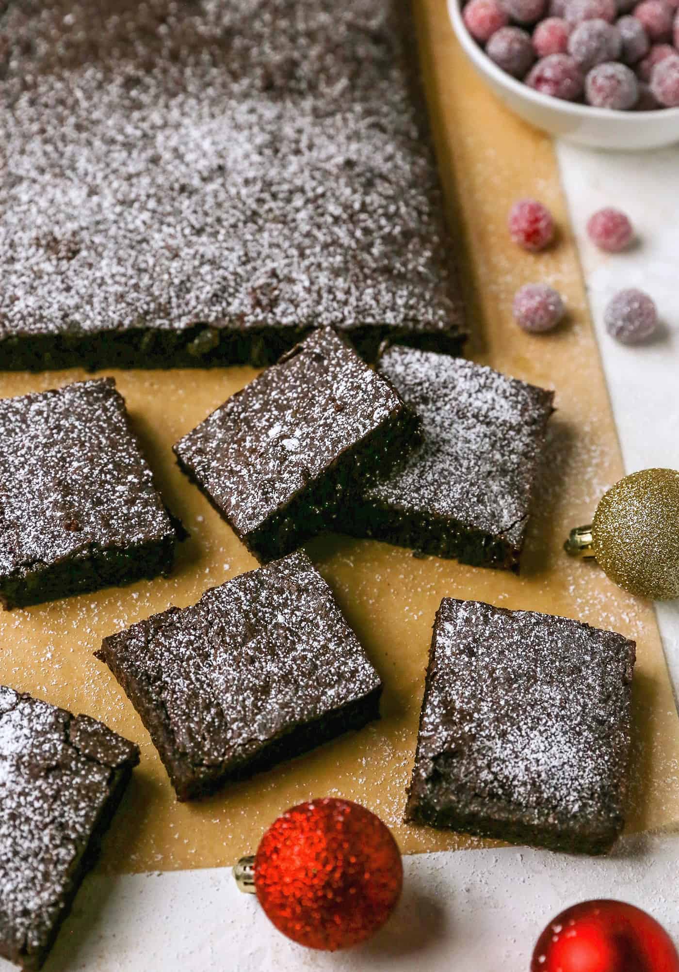 Gingerbread brownies are moist and fudgy, with a touch of molasses and warm spices. A fun holiday twist on a traditional brownie recipe! gingerbread brownies, sugared cranberries, and Christmas ornaments