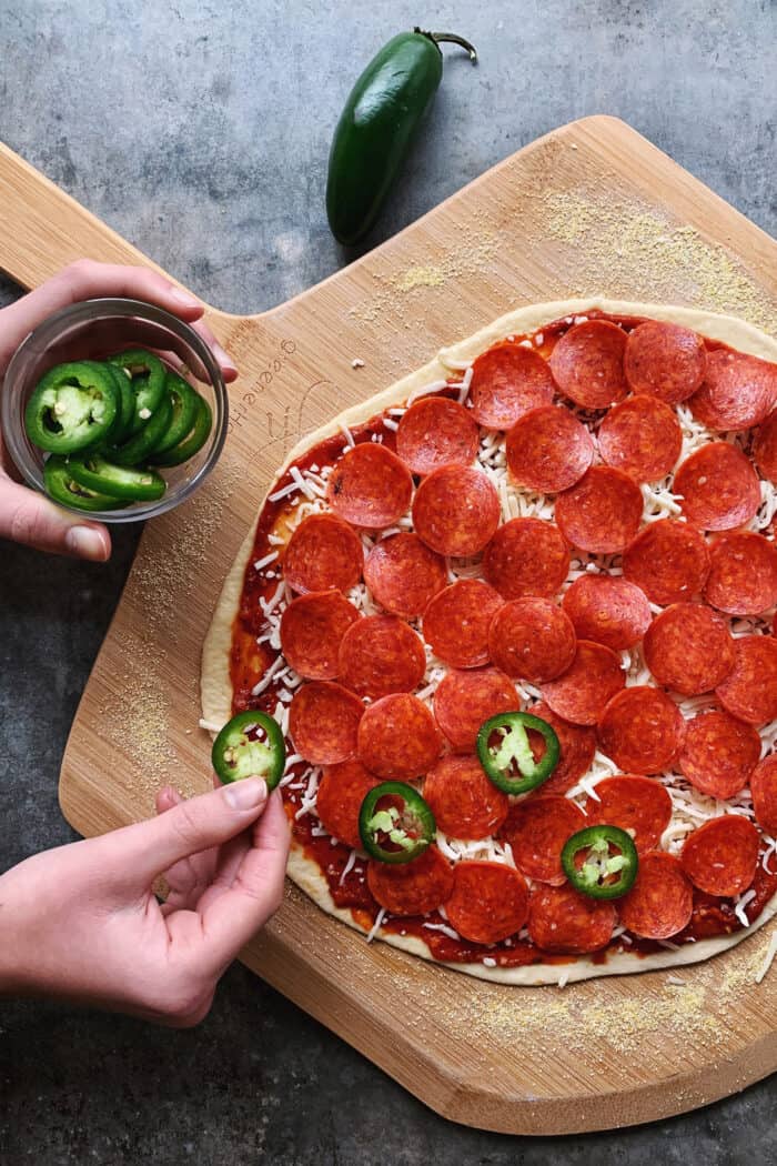An easy recipe for the best homemade pizza sauce. It's a thick, tasty red sauce with fresh tomato flavor, made from simple ingredients! placing jalapeno slices onto pepperoni pizza