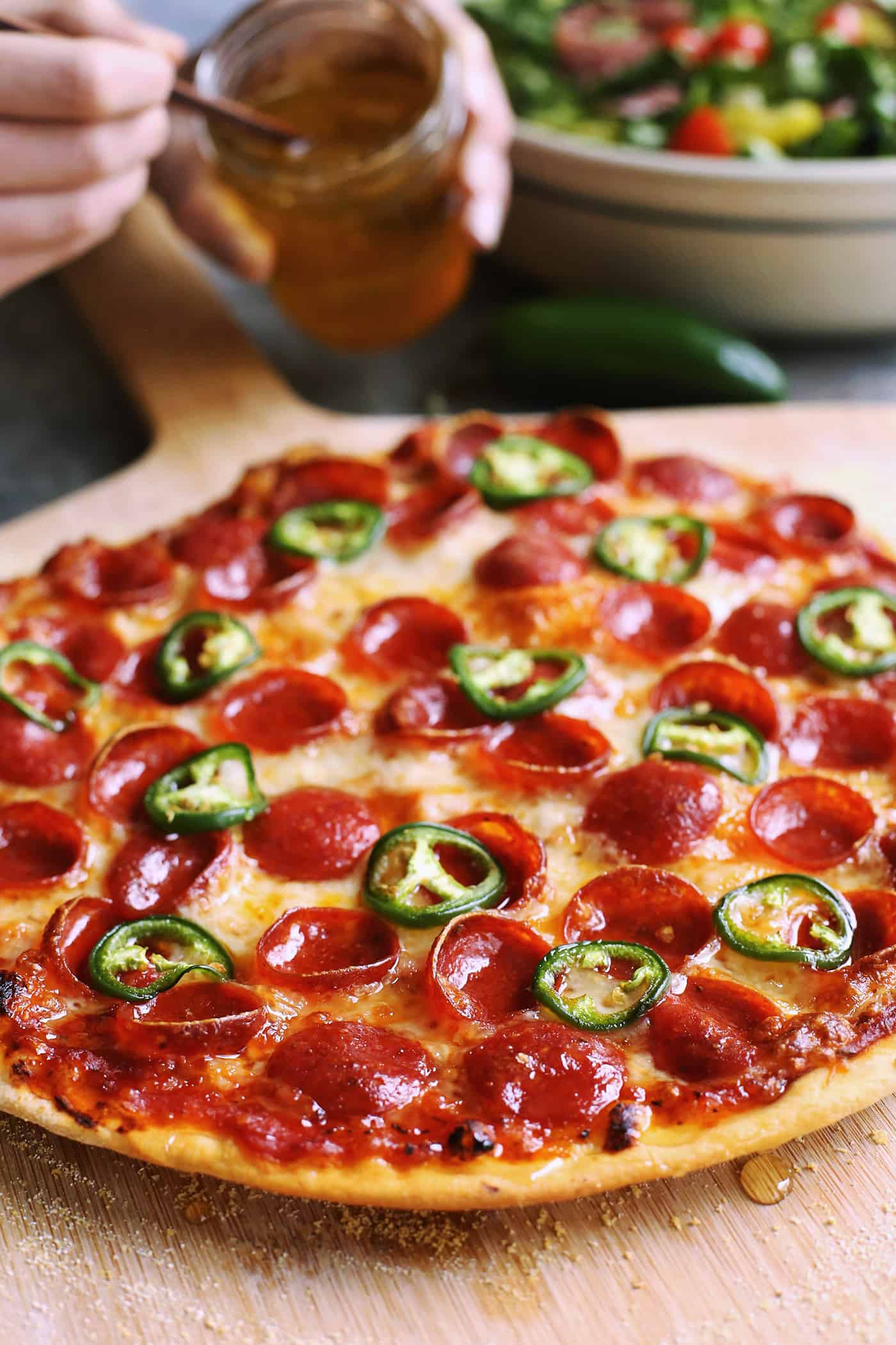 An easy recipe for the best homemade pizza sauce. It's a thick, tasty red sauce with fresh tomato flavor, made from simple ingredients! thin crust pizza with honey, pepperoni, and jalapeno