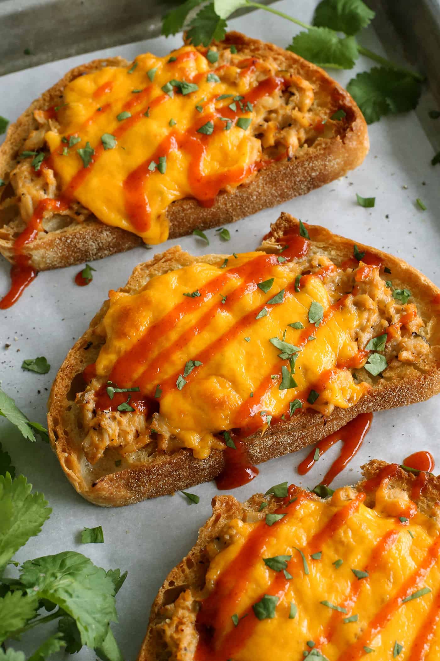 This spicy tuna melt recipe is a quick, easy hot sandwich with tuna, melty cheese, and spicy sriracha made warm and toasty in the oven! sriracha tuna melts on a sheet pan