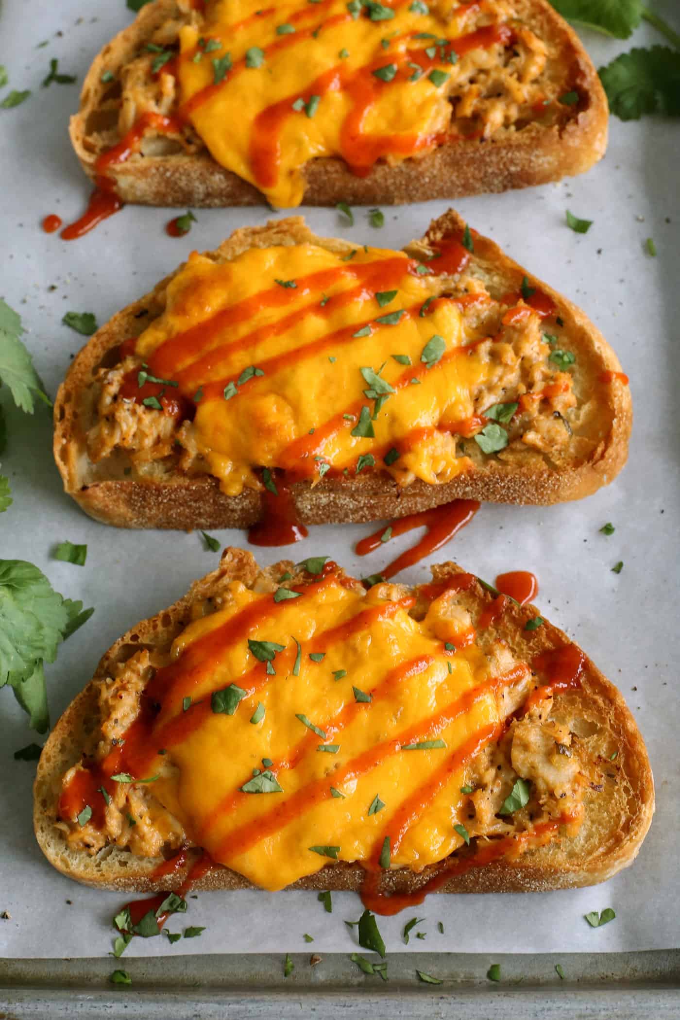 This spicy tuna melt recipe is a quick, easy hot sandwich with tuna, melty cheese, and spicy sriracha made warm and toasty in the oven! tuna melts with cheddar cheese and sriracha