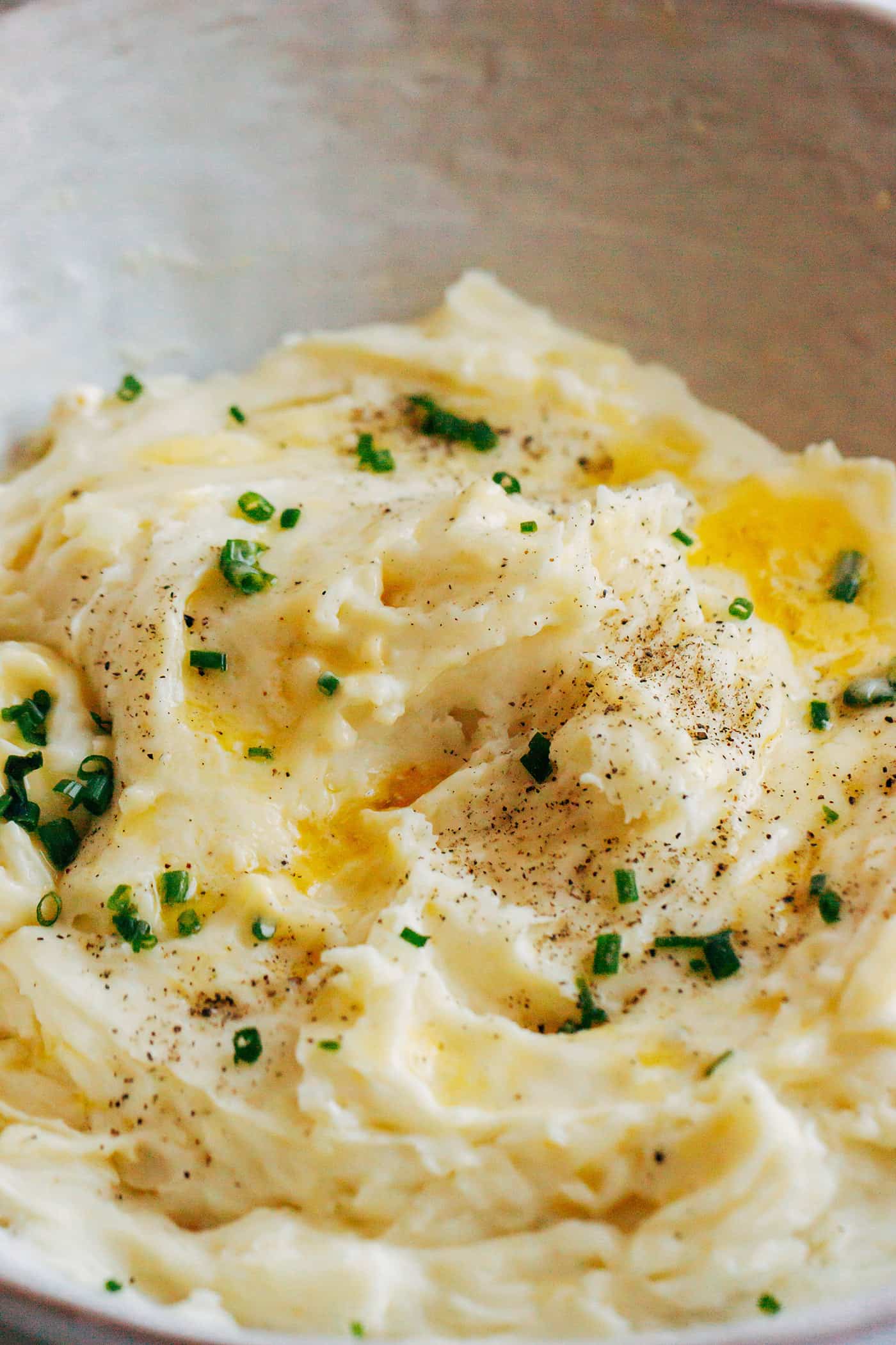 Creamy mashed potatoes with chopped chives as a garnish.