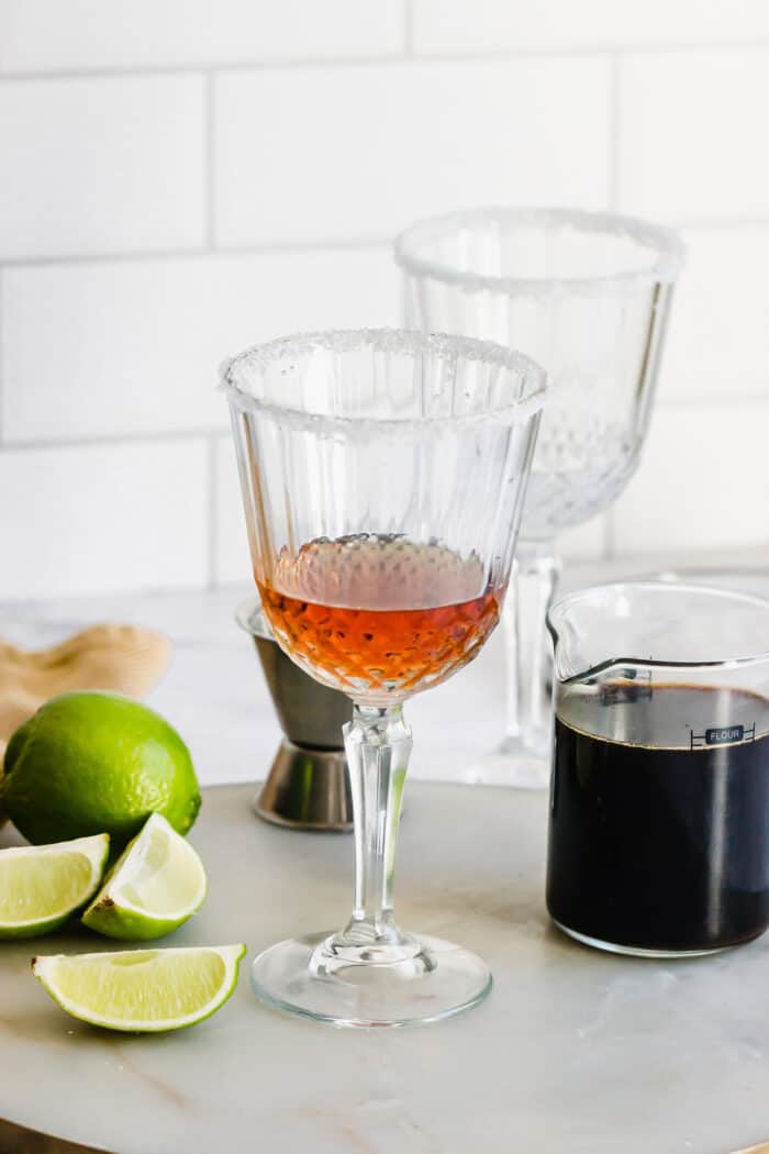 Mexican Coffee is a decadent dessert cocktail that's served hot. With tequila, Kahlua, and whipped cream, this recipe is a fun and beautiful way to top off a meal! liqueurs in a stemmed glass