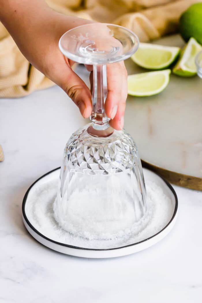 Mexican Coffee is a decadent dessert cocktail that's served hot. With tequila, Kahlua, and whipped cream, this recipe is a fun and beautiful way to top off a meal! dipping the rim of a stemmed glass into a small plate of sugar