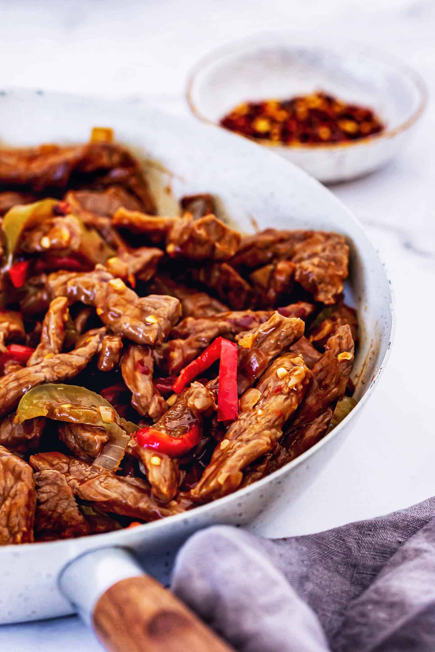 This copycat Beijing beef recipe had tender beef, peppers, and onions tossed in a sweet-spicy homemade sauce. It's even better than takeout! finished dish of Beijing beef