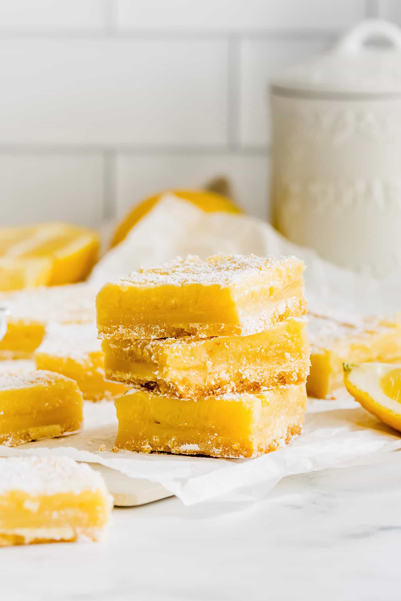 This easy lemon bars recipe is loaded with fresh lemon flavor in a buttery shortbread crust. Only 4 ingredients in the lemon curd filling! lemon bars arranged in a tall stack
