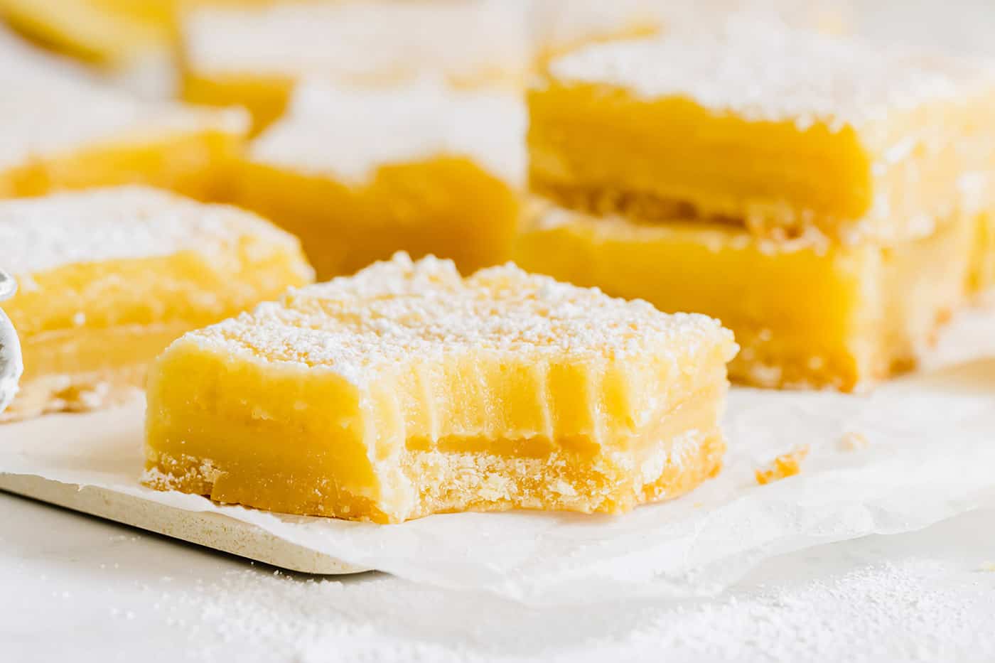 This easy lemon bars recipe is loaded with fresh lemon flavor in a buttery shortbread crust. Only 4 ingredients in the lemon curd filling! a bite out of a lemon bar