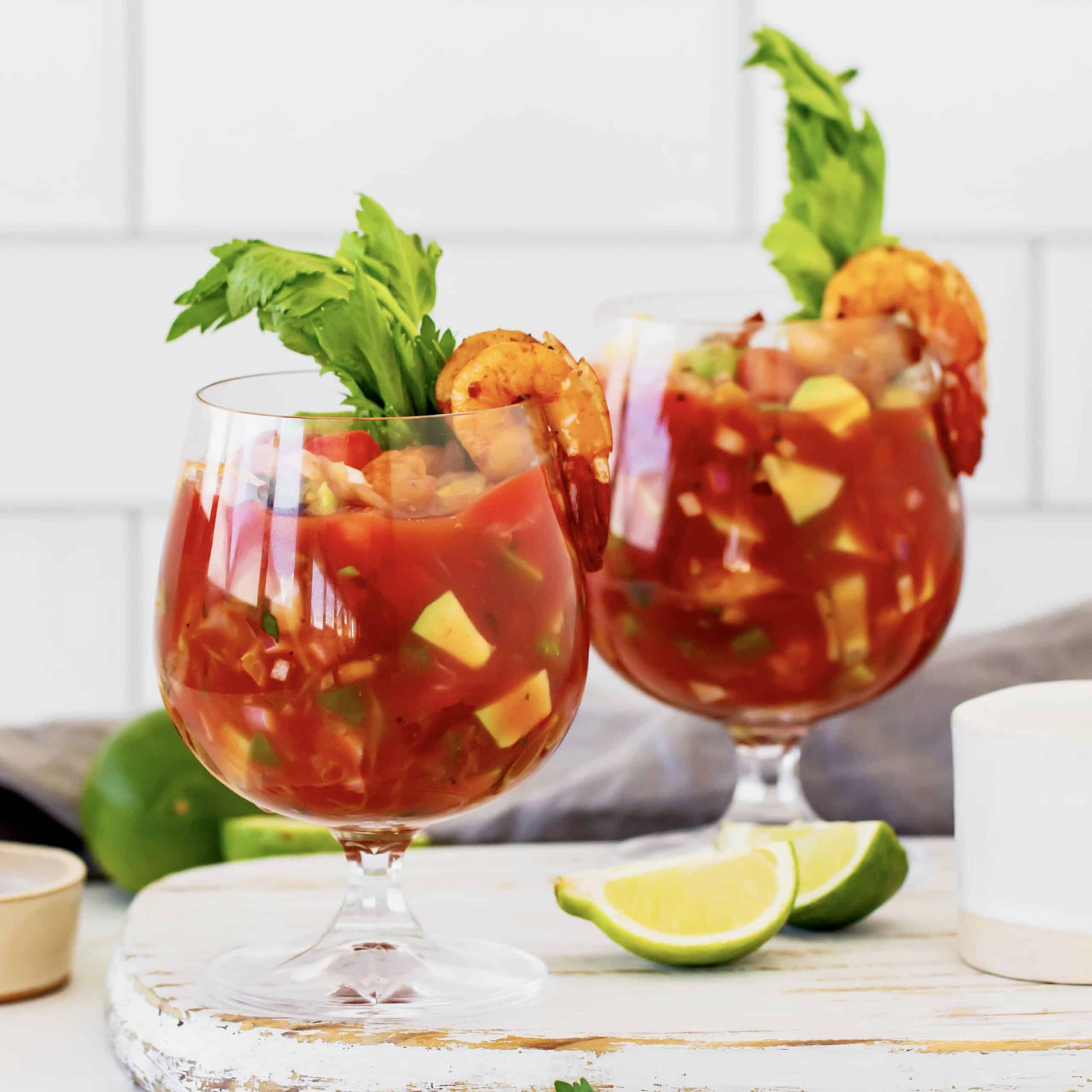 This Mexican shrimp cocktail recipe is a fun twist on a classic appetizer, featuring juicy shrimp and a spicy homemade cocktail sauce! two glasses of shrimp cocktail