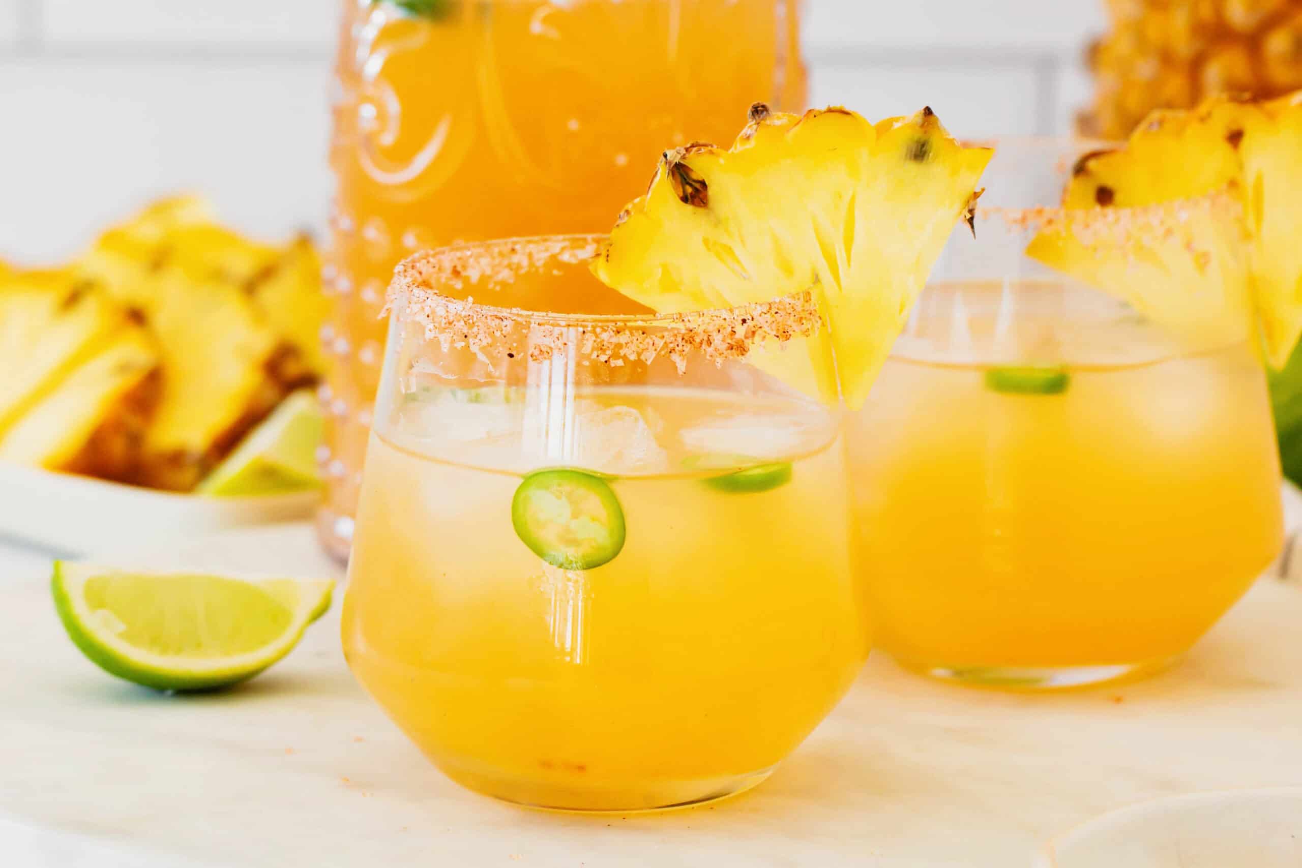 This spicy pineapple jalapeño margarita is a delicious twist on the classic cocktail with blanco tequila, fresh pineapple juice, and jalapeño. glasses of pineapple margaritas with jalapeno