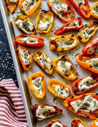 mini sweet peppers that were grilled and then filled with goat cheese, on a sheet pan