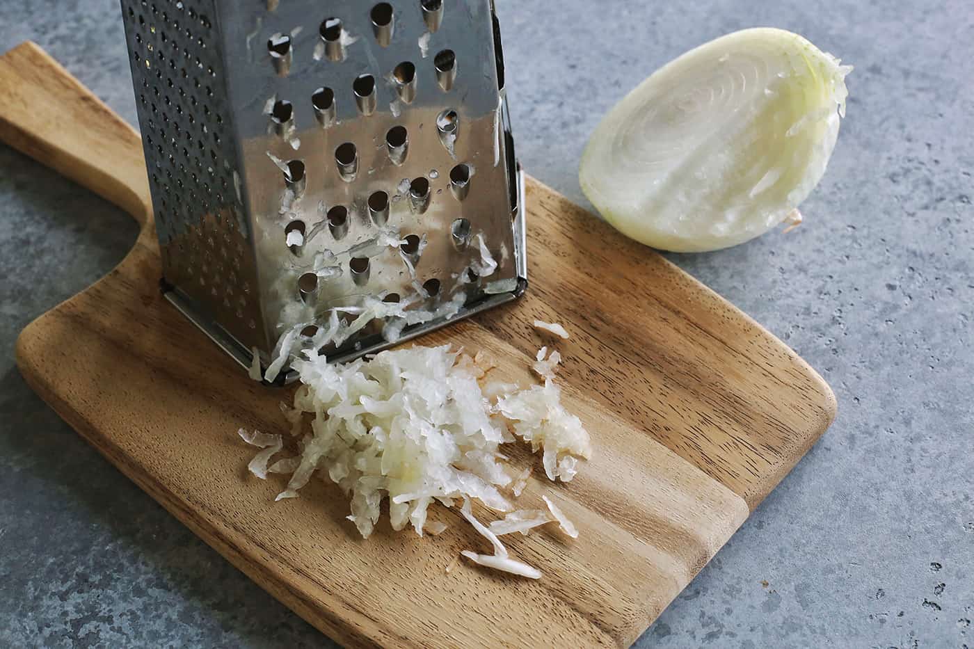 This crunchy, creamy coleslaw recipe is a favorite BBQ side. Serve it as a cooling accompaniment to grilled meats, tacos, or pulled pork! grating a yellow onion on a box grater