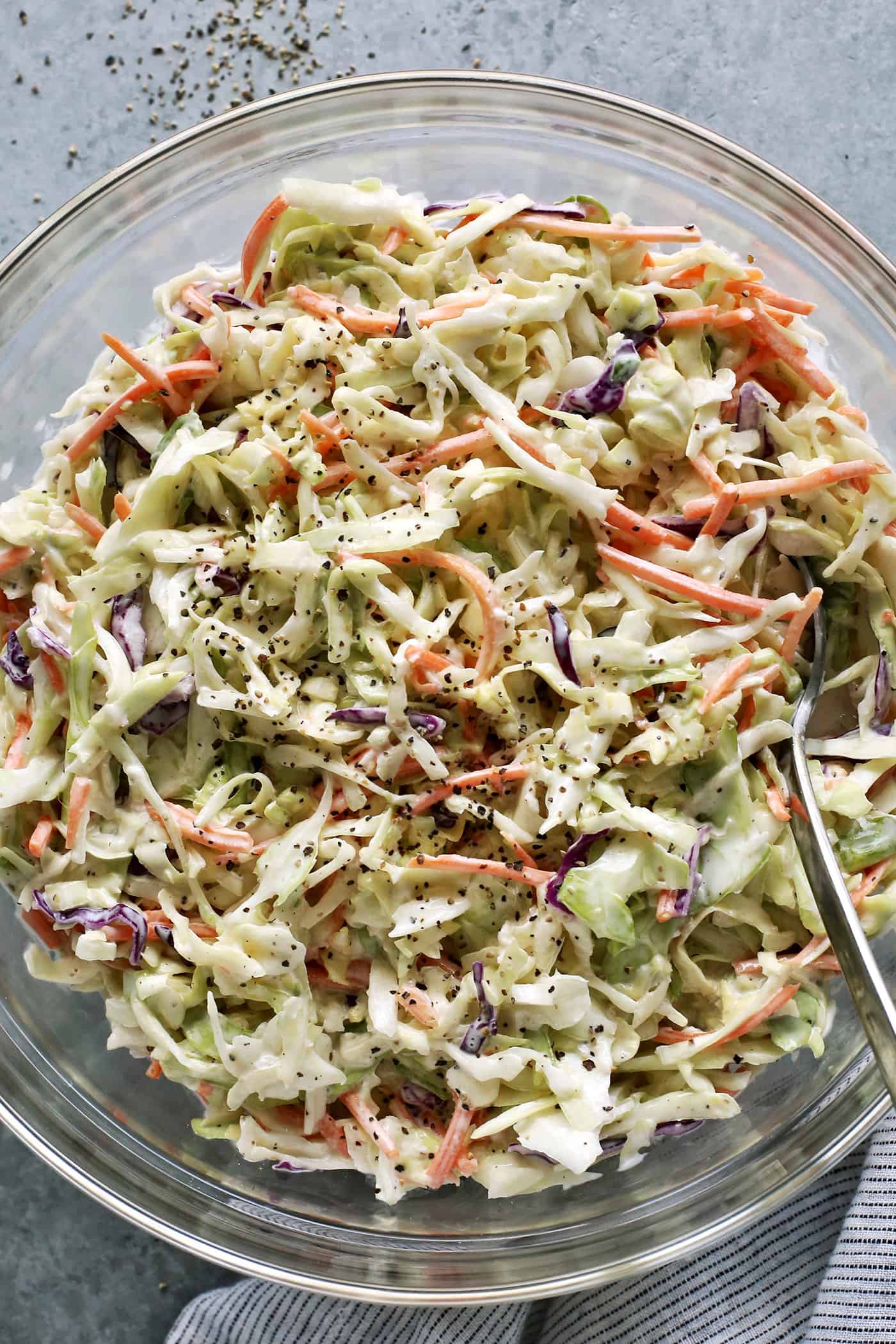 This crunchy, creamy coleslaw recipe is a favorite BBQ side. Serve it as a cooling accompaniment to grilled meats, tacos, or pulled pork! coleslaw with a creamy dressing in a large clear bowl