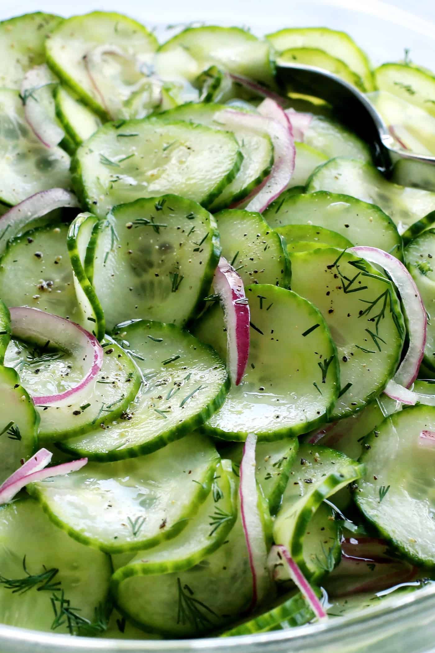 This easy cucumber salad recipe is a refreshing summertime side dish with thinly sliced cucumbers and onion, plus a tangy vinegar dressing. cucumber salad with vinegar in a clear bowl