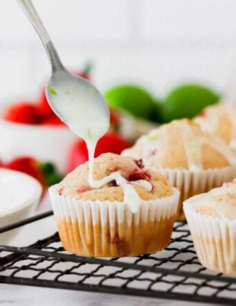 Drizzling lime glaze onto strawberry muffins