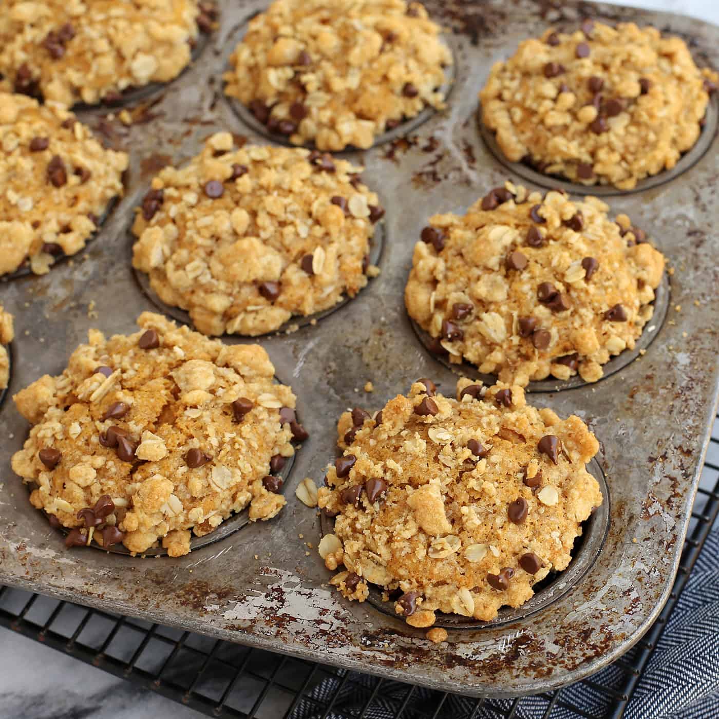 Super moist and perfectly spiced, this pumpkin muffins recipe features a crispy, buttery oat streusel dotted with melty chocolate chips. Pumpkin streusel muffins in a muffin tin.