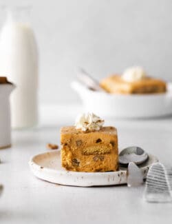 Square of Pumpkin Icebox Cake on plate with spoon, topped with whipped cream