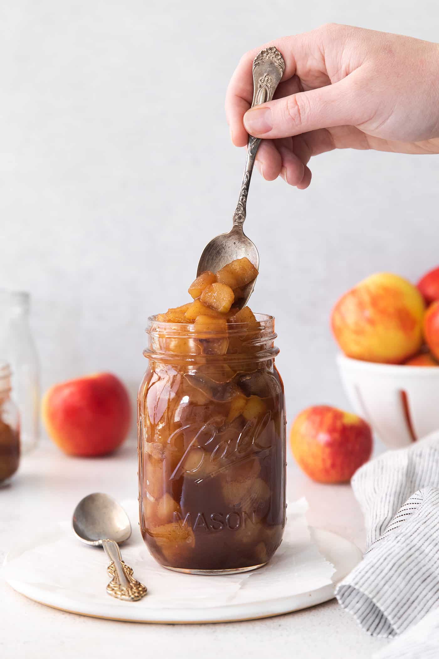 This easy homemade applesauce recipe can be made smooth or chunky, with simple refrigerator storage or canning for long-term pantry storage! spooning into a jar of homemade applesauce