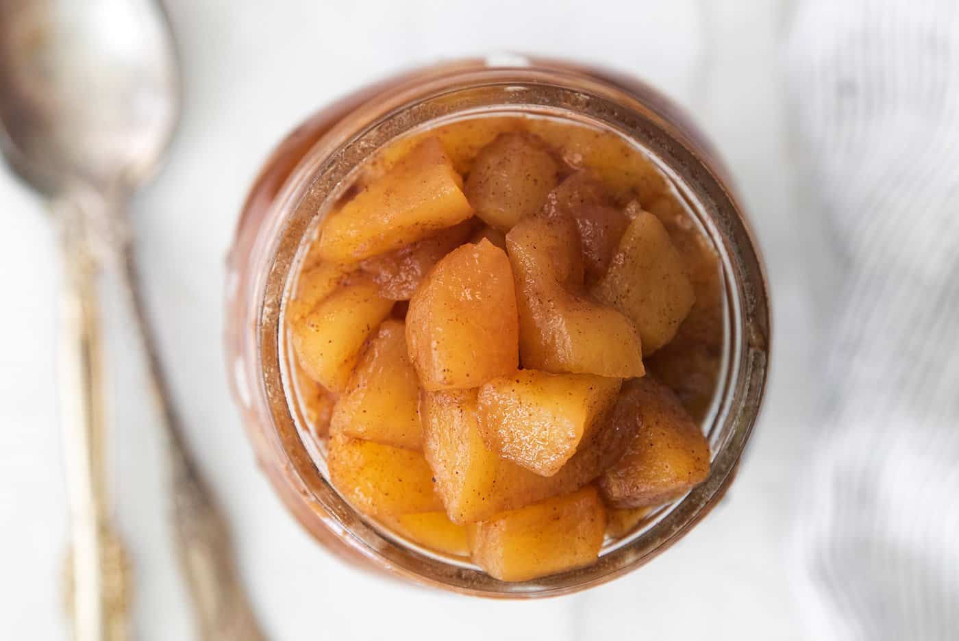This easy homemade applesauce recipe can be made smooth or chunky, with simple refrigerator storage or canning for long-term pantry storage! close-up of chunky homemade applesauce in a jar