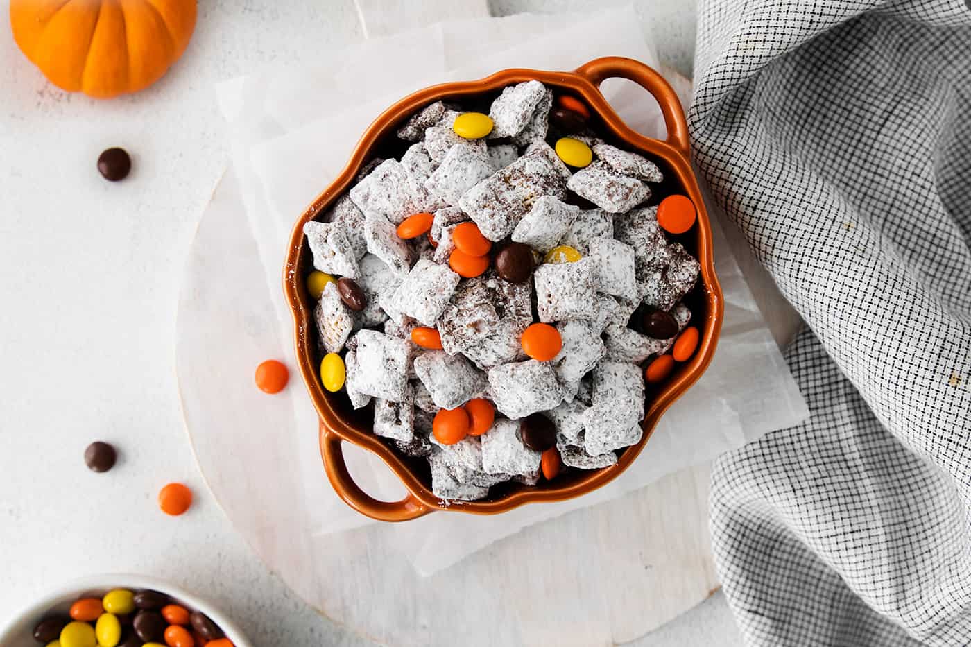 Overhead view of fall-themed puppy chow inside a pumpkin-shaped bowl.