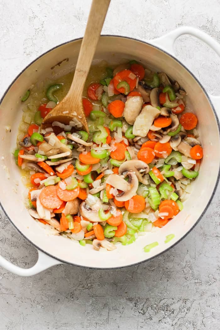 Vegetables for chicken wild rice soup cooking in Dutch oven