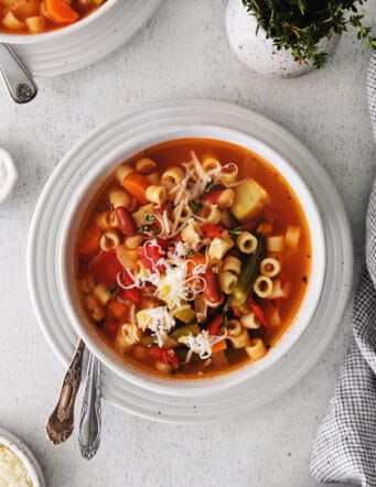 Overhead view of a bowl of minestrone soup topped with parmesan