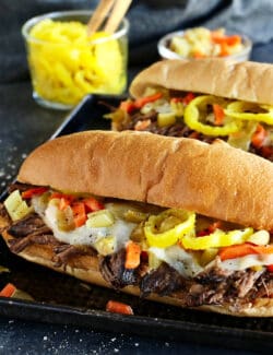 Slow cooker Italian beef in a hoagie sandwich with provolone cheese and peppers