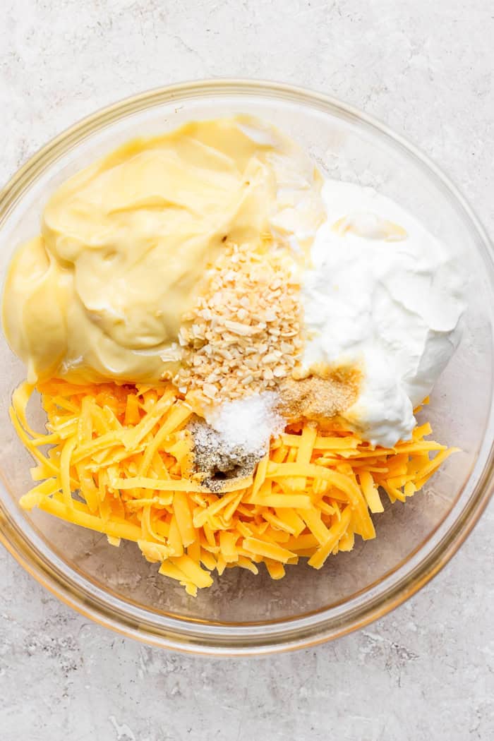 This cheesy hashbrown casserole recipe is an easy side dish that’s ready in under an hour. You'll love the crispy cornflake topping! Ingredients for cheesy hashbrown casserole sauce in bowl before stirring