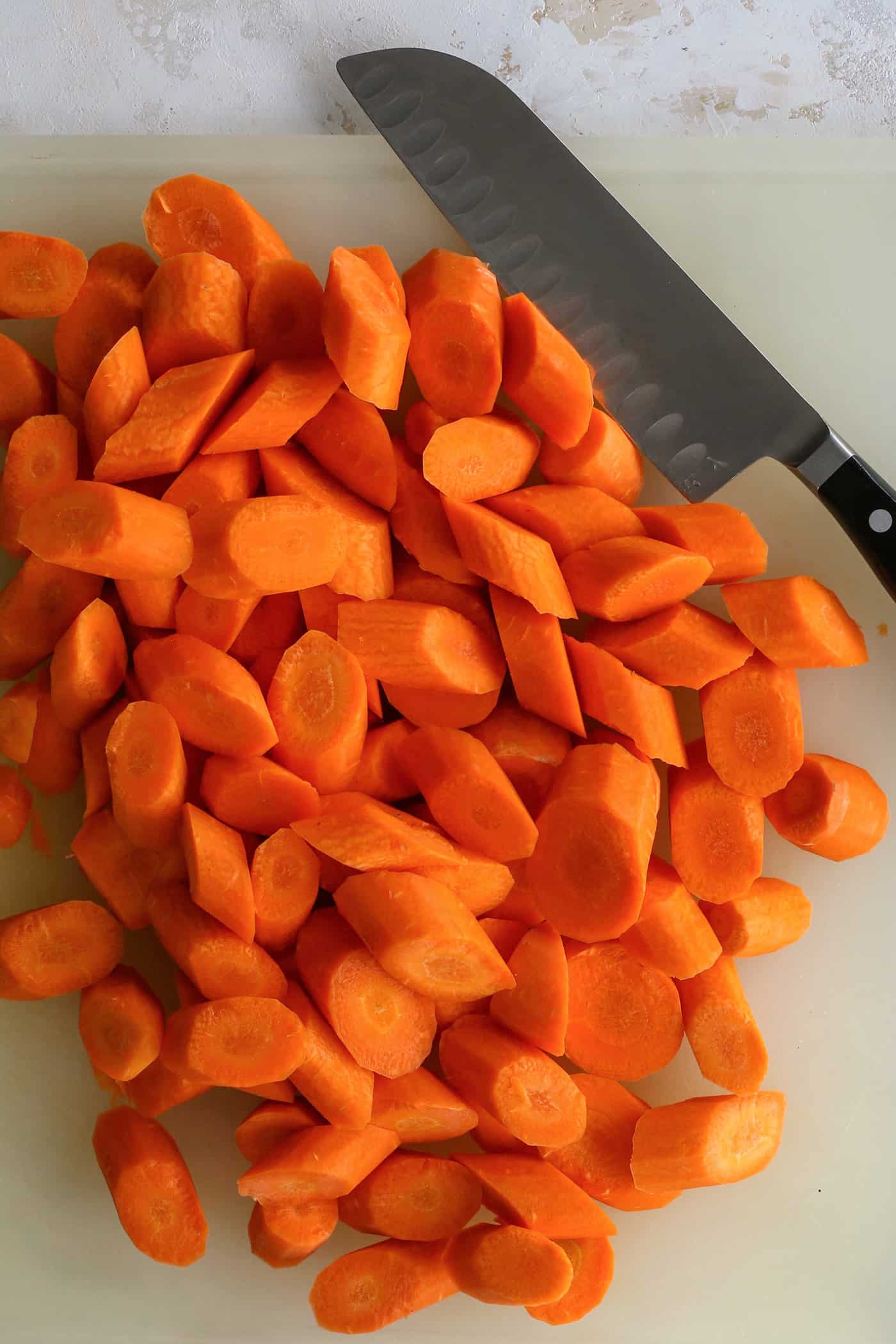 If you've had a bag of carrots hanging around for a while, you may ask yourself, How Long Do Carrots Last in the Fridge? I'm here to help. cutting carrots on a cutting board