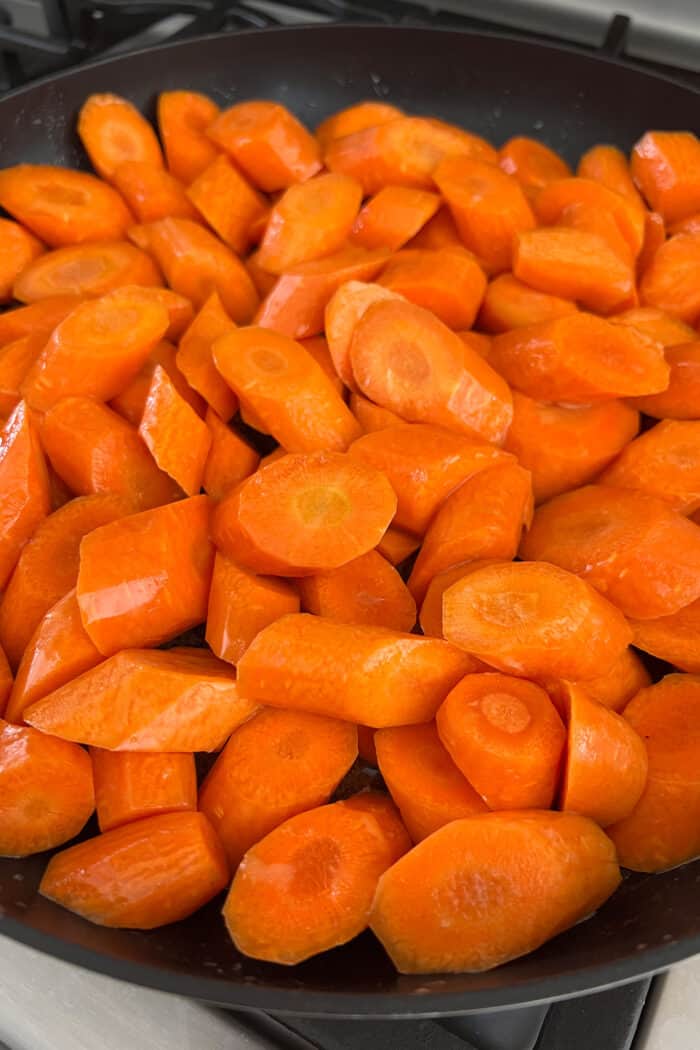 Tossed in a mixture of cinnamon, brown sugar, and honey, these Candied Carrots are perfectly sweet and savory. A quick & easy side dish! cut carrots in a skillet