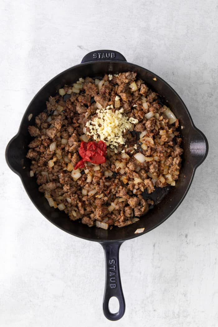 This skillet lasagna recipe has all the classic lasagna ingredients, without the extra dishes and layering! Perfect for weeknight dinners. Ground sausage, onion, garlic, and tomato paste in a skillet