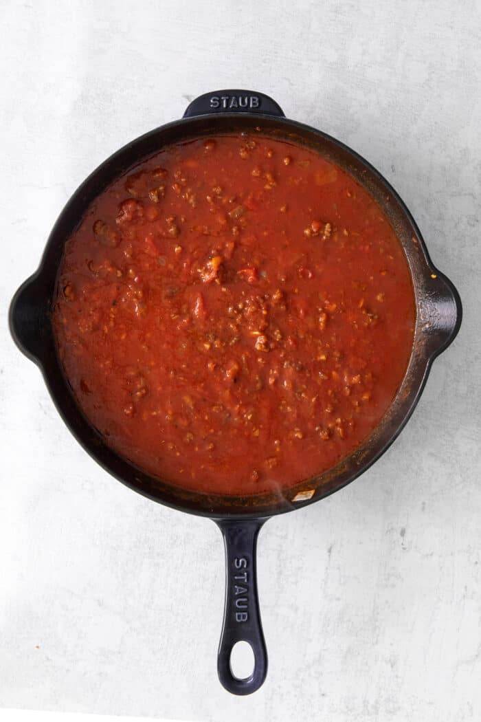 This skillet lasagna recipe has all the classic lasagna ingredients, without the extra dishes and layering! Perfect for weeknight dinners. Marinara sauce in a cast iron skillet