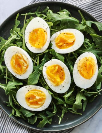 Air fryer hardboiled eggs on a bed of arugula