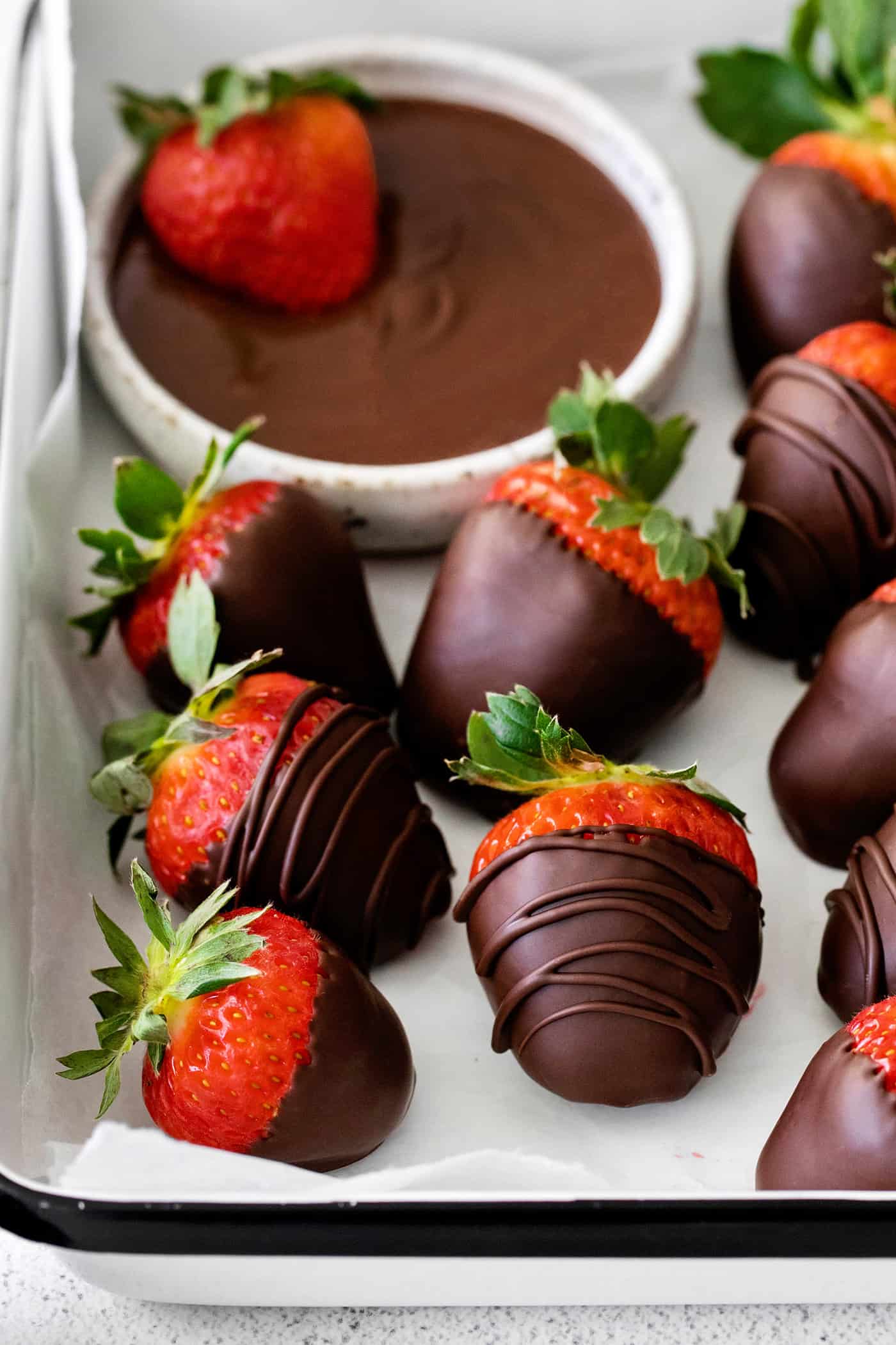 These Chocolate Covered Strawberries may look fancy and elegant, but are actually a quick and easy treat to make, with just 3 ingredients! Close-up of chocolate covered strawberries on a dish