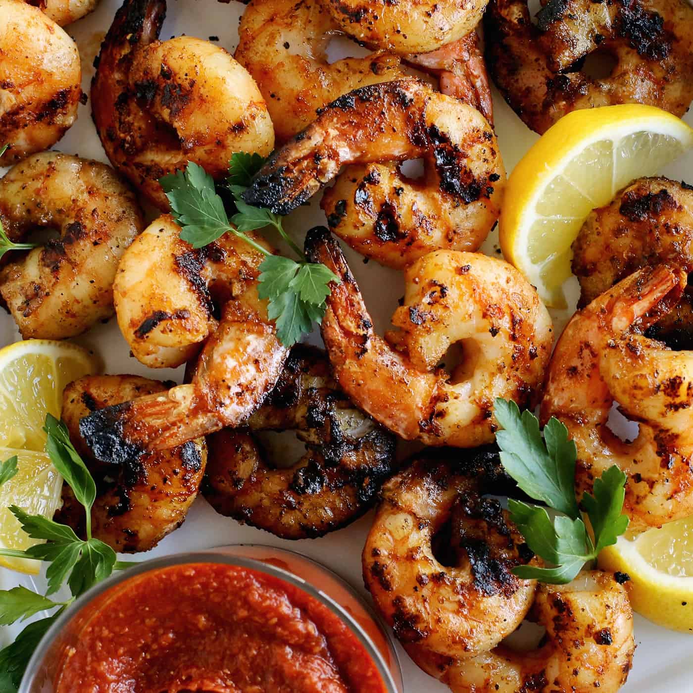 Tossed with olive oil and a few spices, this easy shrimp cocktail is perfectly flavored and grilled until just charred. So good! Overhead view of grilled shrimp cocktail.