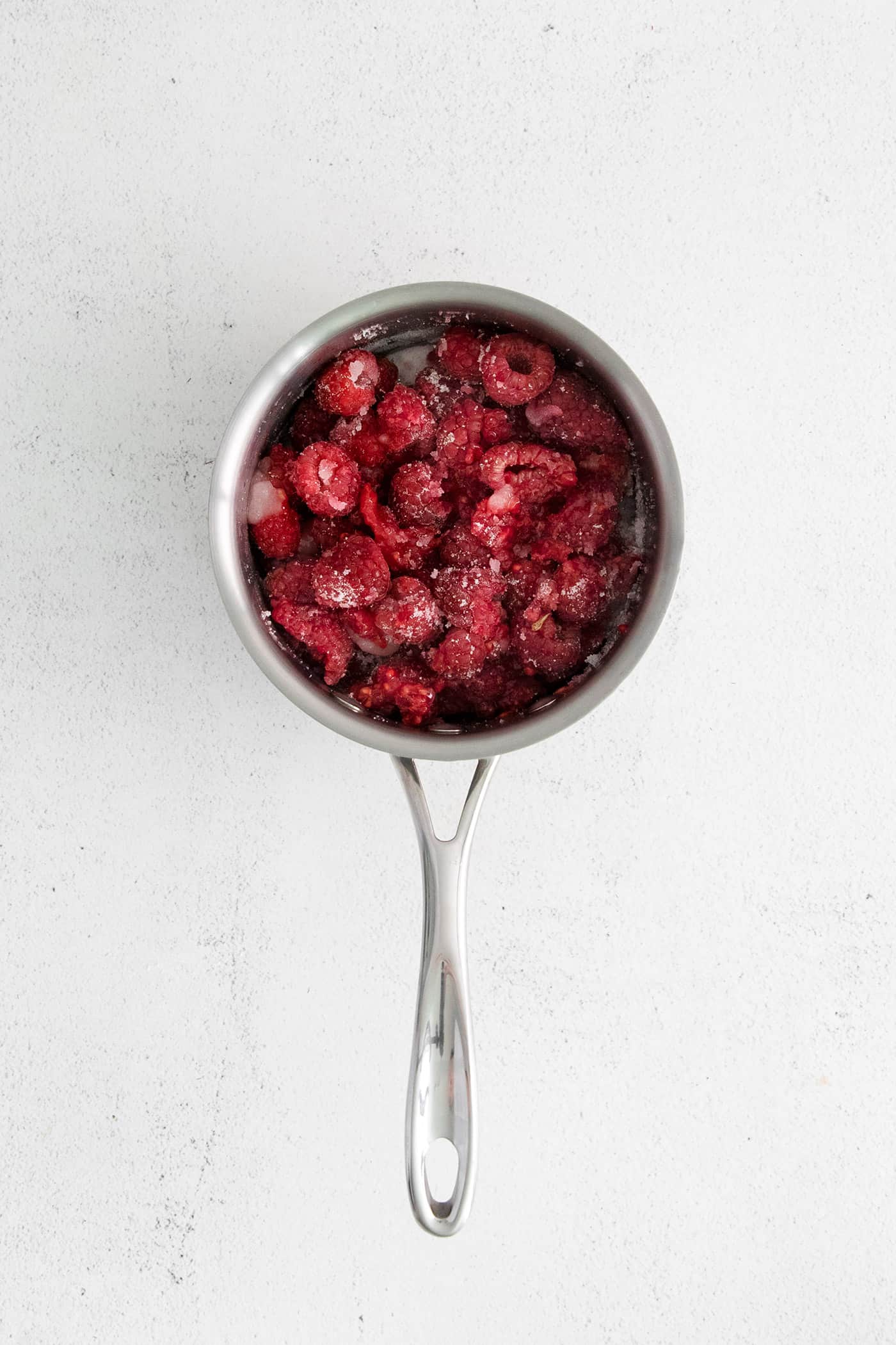 Sweet, bright, and intensely fruity this Raspberry Sauce makes a great topping for angel food cake, cheesecake, ice cream, and more. Raspberries with lime juice and sugar in a sauce pan