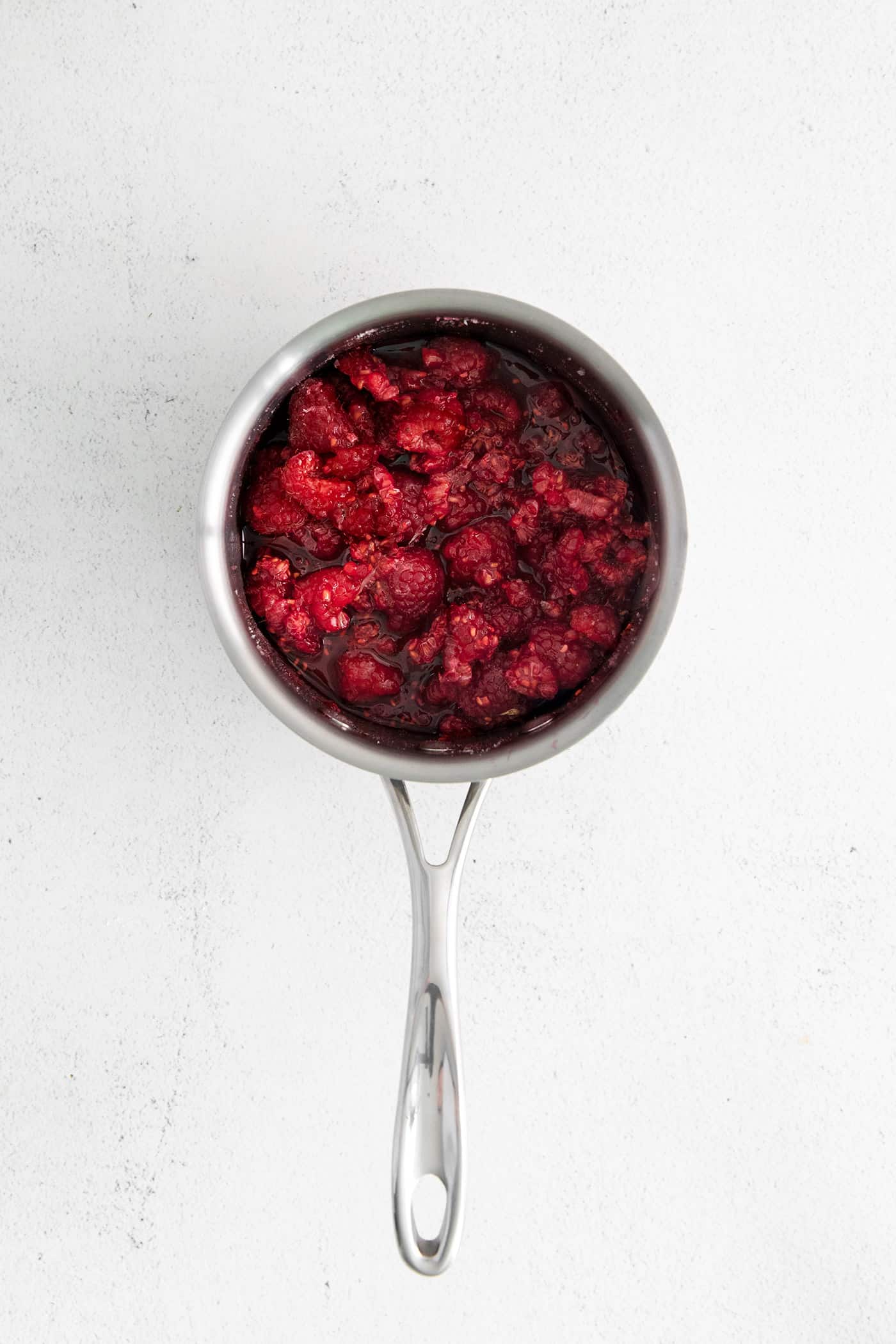 Sweet, bright, and intensely fruity this Raspberry Sauce makes a great topping for angel food cake, cheesecake, ice cream, and more. Macerated raspberries in a saucepan