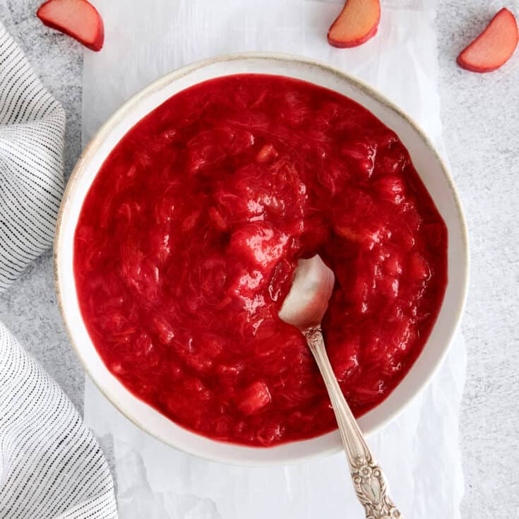 A bowl of rhubarb sauce with a spoon in it