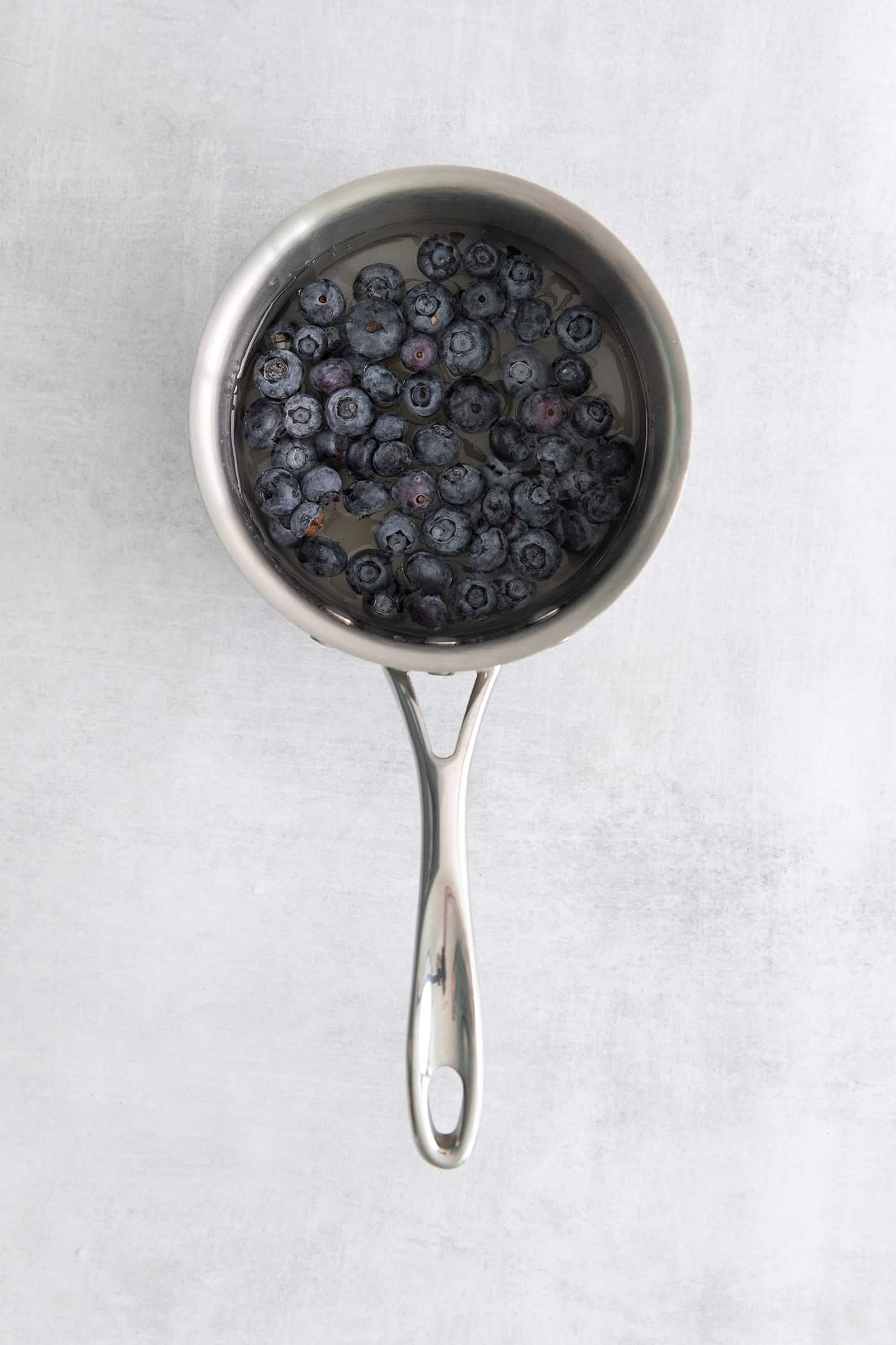 Made with flavored simple syrup, this Blueberry Margarita is just the fruity cocktail for summer. Sweet but tart and super refreshing! Blueberries in a small pan with water and sugar