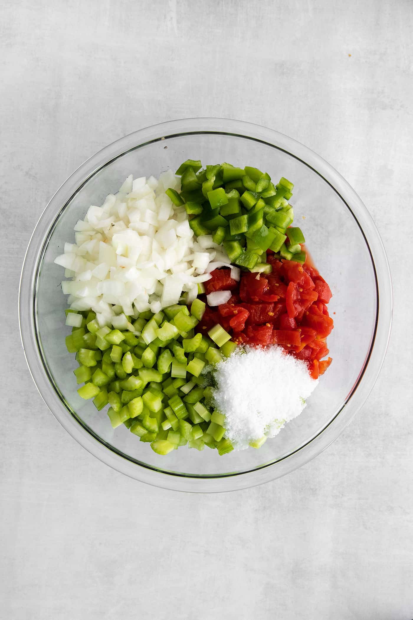 Made with juicy tomatoes, celery, onion, and green pepper these Chili Stewed Tomatoes make a mouthwatering side dish. Peppers, tomatoes, celery, and onions in a glass bowl