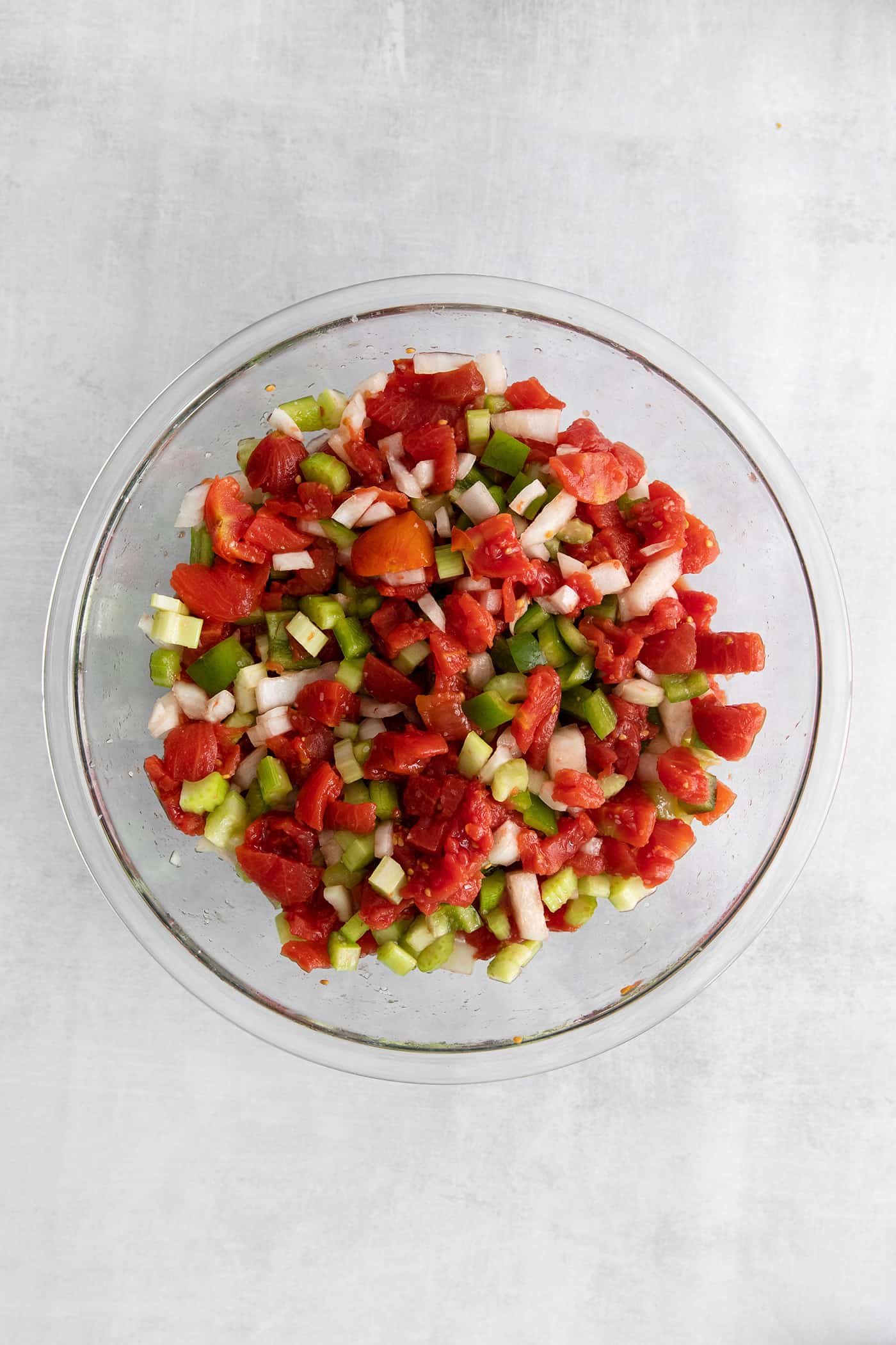 Made with juicy tomatoes, celery, onion, and green pepper these Chili Stewed Tomatoes make a mouthwatering side dish. Diced veggies in a glass bowl