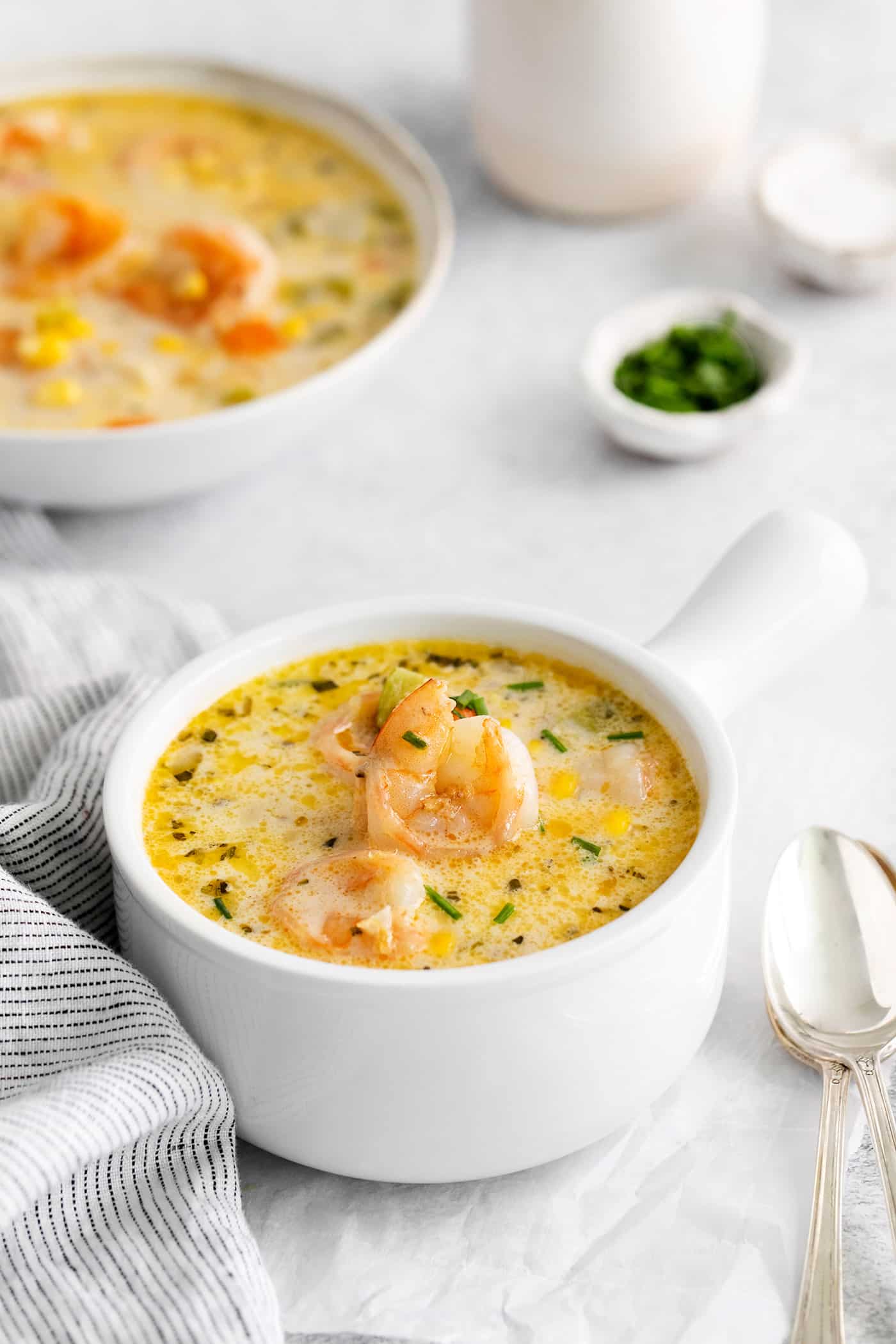This shrimp and corn chowder has a light, creamy broth and is filled with sautéed vegetables, tender shrimp, and fresh sweet corn. Angled view of a bowl of shrimp and corn chowder