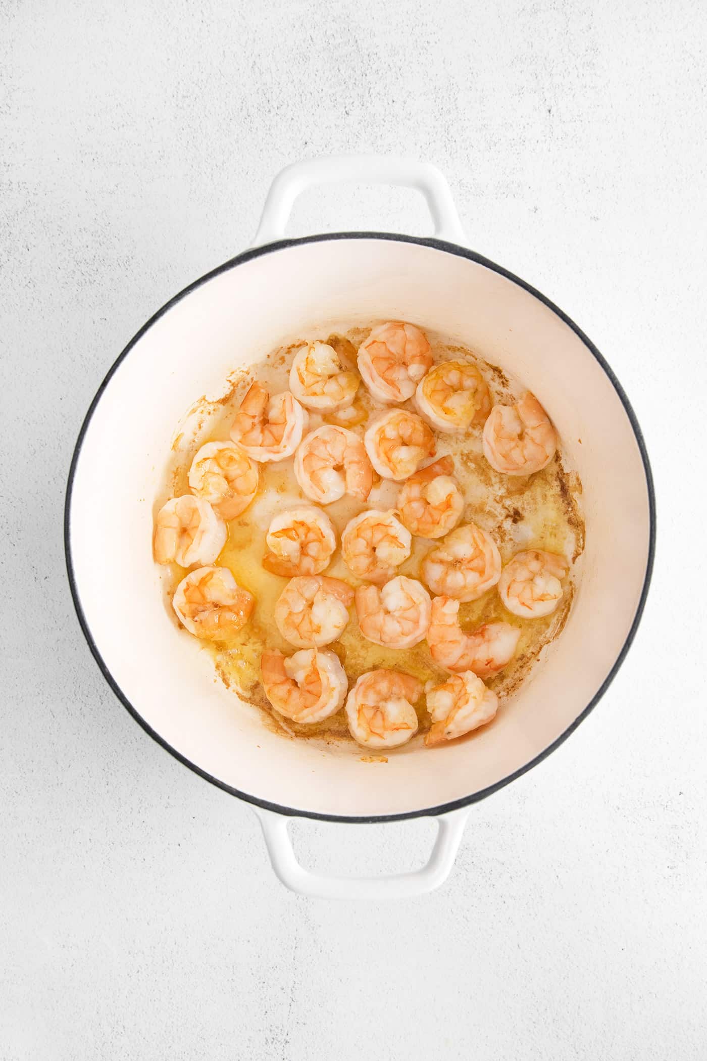 This shrimp and corn chowder has a light, creamy broth and is filled with sautéed vegetables, tender shrimp, and fresh sweet corn. Shrimp sauteing in a pan
